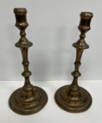 A pair of 18th Century bell metal candlesticks with waisted sockets above a knop stem to gadrooned