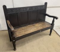 A late Victorian carved oak hall settle with plank seat on turned legs 137 cm wide x 53.