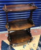 A Victorian rosewood whatnot with three shaped tiers and C scroll supports raised on ringed and