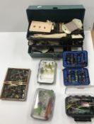 A box containing a collection of various fishing flies including a vintage hand annotated book of