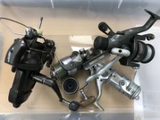 A collection of four various reels including a Shimano Big Bait Runner, a Mitchell Predator 600,