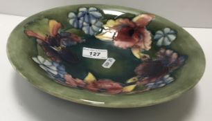 A William Moorcroft iris and spring flowers pattern bowl, green ground,