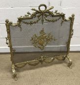 A vintage brass framed fire screen in th