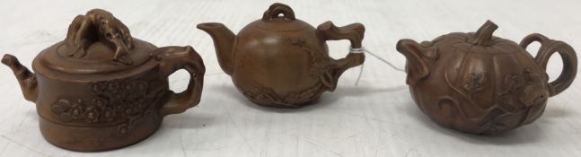 A collection of three miniature carved wooden model teapot ornaments in the Chinese taste,