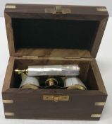 A pair of modern brass and mother of pearl mounted opera glasses housed in a wooden box,