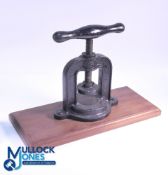 Cast-iron Golf Ball Press - horseshoe shaped mounted on a circular base, screwed to wooden base,