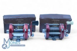 Two Abu Ambassadeur multiplier reels, a black handle model, with grooved 3 screw end plates, star