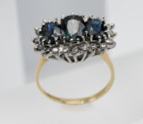 A large three stone sapphire and diamond cluster ring, set in 18ct yellow gold, size Q.