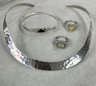 A modern 'hammered' silver open back torque necklace, together with silver and black stone bangle