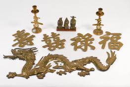 A brass dragon wall decoration, together with a pair of brass candle sticks and a set of four