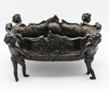 A heavy bronze planter modelled as four cherubs carrying a basket, height 17cm, length 36cm
