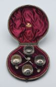 Set of four Victorian silver table salts with three spoons (one damaged) in original fitted case