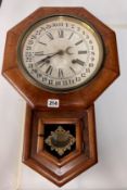 A Victorian drop dial wall clock with key and pendulum by Ansonia clock company with Roman and