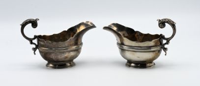A pair of George V Sheffield silver sauce boats with letter C scroll handles approx. 14.25oz (one
