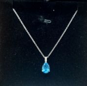 An 18ct white gold diamond and topaz pendant on chain.