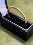 An 18ct yellow gold and diamond set bangle, approx. 17.8g, with purchase receipt dated 1990.