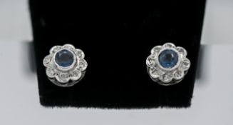 A pair of 9ct white gold diamond an topaz 'Flower' style studs.