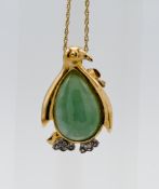 A 10k gold penguin brooch/pendant on fine chain set with green stone.