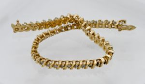 A 14k yellow gold tennis bracelet set with forty nine diamonds, length 19cm (diamonds not in uniform