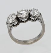 An 18ct white gold three stone diamond ring, centuring on a round brilliant cut diamond, flanked