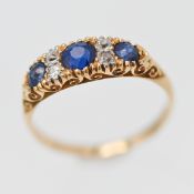 An 18ct yellow gold ring set with diamonds and three sapphires, size M