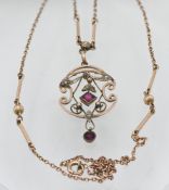 A 9ct gold Art Nouveau garnet and seed pearl pendant on chain.
