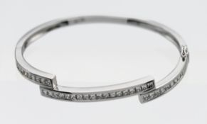 An 18k white gold set diamond zig zag channel set bangle, 36 princess cut diamonds with a hinged