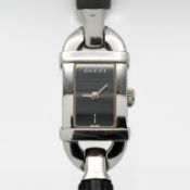 Gucci, a ladies rectangular black linen dial, leather bangle, model number 6800L, boxed.