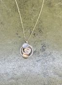 A yellow and white gold set abstract swirl and white stone pendant stamped 750 Italy on a trace link