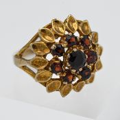 A 9ct yellow gold and garnet dress ring with leaf decoration, size K.