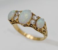 A fine quality 18ct yellow gold three stone opal and diamond ring cluster, size Q, in Garrard & Co