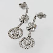 A pair of 18ct white gold diamond 'Flower' design drop earrings.