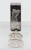 A silver money clip with golfer decoration and an ARP silver badge (2 27.5g)