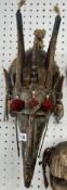 A large African Dan mask, metal and wood with tassels.