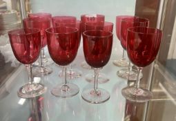 A collection of nine cranberry wine glasses.