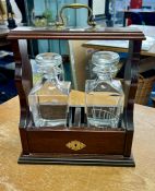 A two bottle glass tantalus with mahogany carrying case with glass mounts, height 38cm (lacks key)