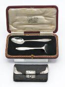 A silver baby spoon and pusher, weighs 31g, in fitted box. Together with a silver mounted vintage