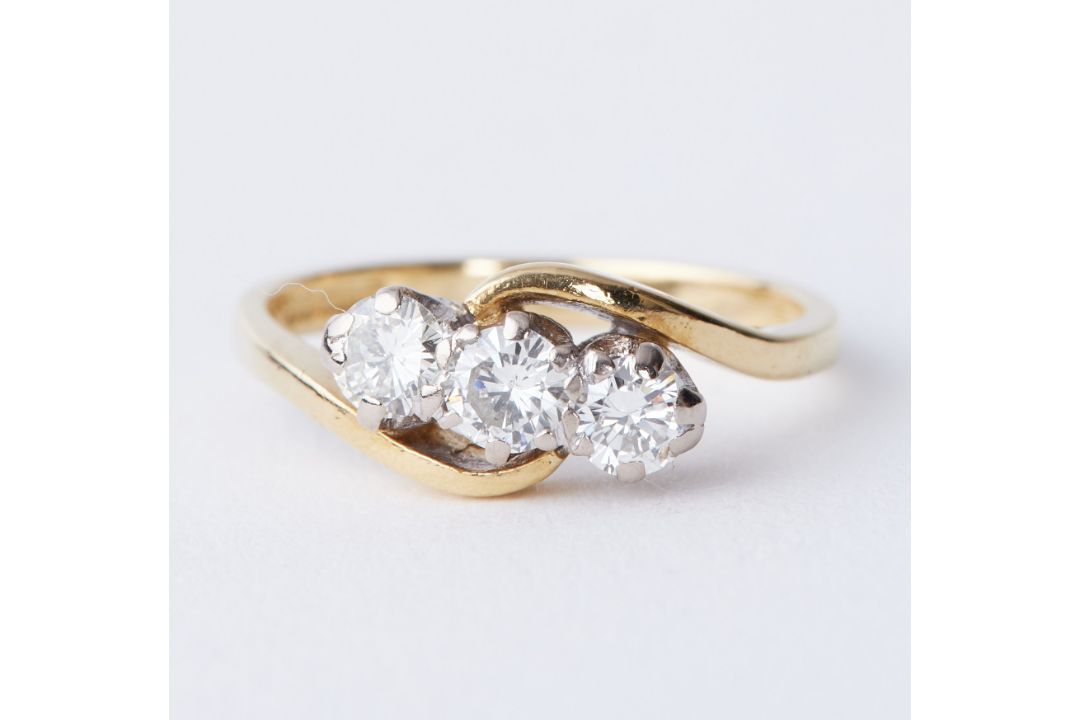 An 18ct yellow & white gold twist design ring set with three round brilliant cut diamonds, approx.