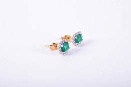 A pair of 18ct white & yellow gold cluster style earrings set with a central emerald cut emerald,