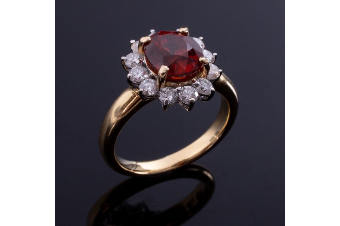 An 18ct yellow gold cluster ring set with a central oval cut orange garnet, approx. 2.50 carats, - Image 1 of 2