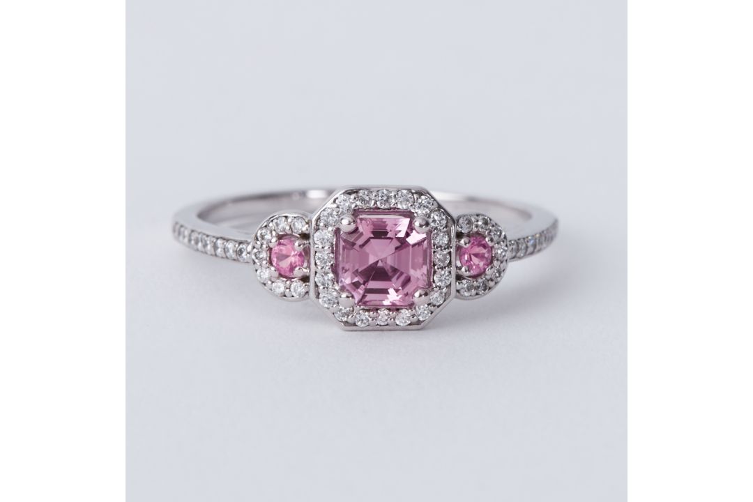 An 18ct white gold ring set with a central pink sapphire with a round pink sapphire to each side and