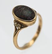 A 9ct gold and black opal set ring, embellished with four further diamonds on the shoulders,
