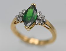 An 18ct diamond and green garnet ring, size N/O.