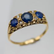 An 18ct sapphire and diamond set three stone ring, size R/S.