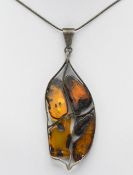 An unusual arts and crafts style amber and white metal set pendant, length 10cm including pendant