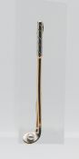 An 18ct gold and platinum brooch in the form of a golf club, length 63mm.