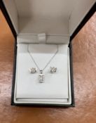 A three piece diamond and white gold set comprising pendant necklace and a pair of earrings, stamped