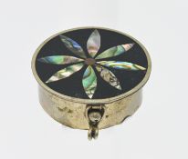 A white metal pill box, lid inlaid with mother of pearl.