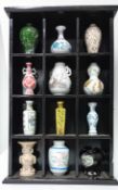 A quantity of 24 reproduction Chinese miniature vases and bowls, in display cabinets. (26)