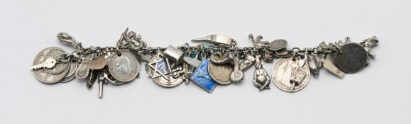 A white metal charm bracelet comprising silver and white metal charms and 19th and 20th century